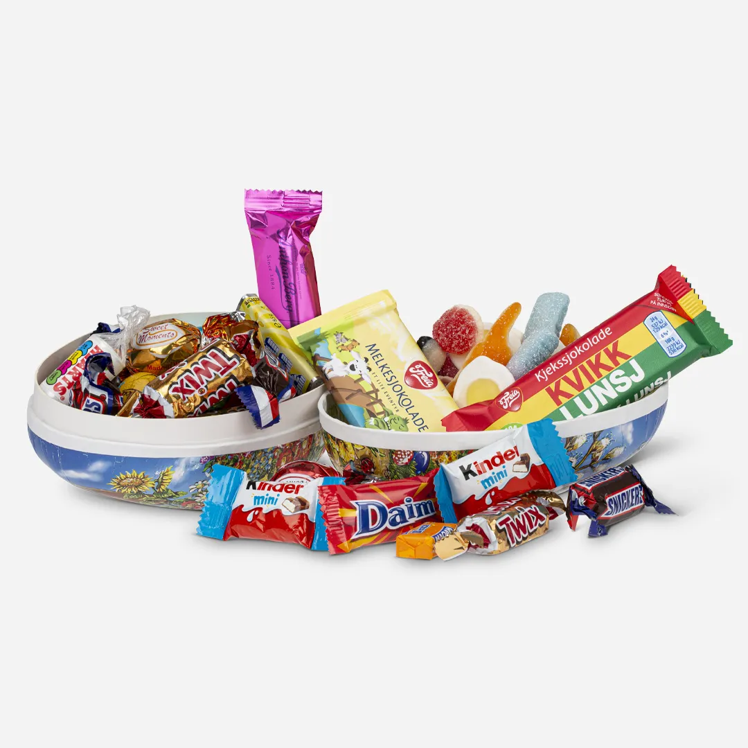 Påskeegg 18cm Smågodt Og Sjokolade 550g - Innhold: Smågodt 300g, Innpakket Sjokolade Classic 150g , Eventyr Melk 24g, Kvikk Lunsj 24g, Anthon Berg Marsipanbrød 25g Et påskeegg delt i 2, fylt med smågodt og innpakket sjokolade i en halvdel samt litt liggende utenfor